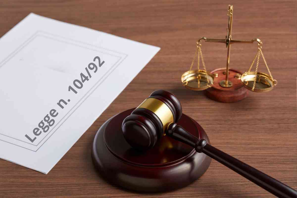 martello e bilancia della giustizia, su un foglio scritto legge 104/92