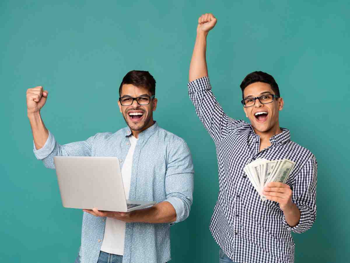 ragazzi con soldi in mano e pc