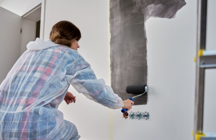 donna che tinteggia le pareti
